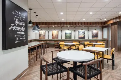 a dining room with tables and chairs and a chalkboard at Fairfield by Marriott Inn & Suites Anaheim Los Alamitos in Los Alamitos