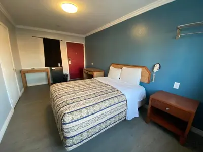 a hotel room with a bed and a table at Sands Inn in South Gate