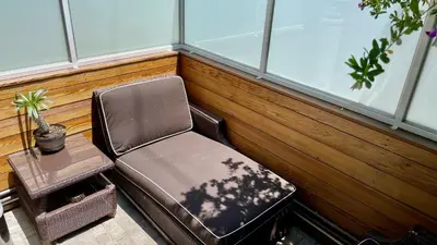 a chair and a ottoman in a room with windows at Hollywood’s Suite in Los Angeles