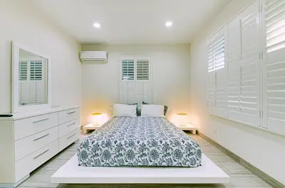 a white bedroom with a bed and two lamps at Stylish Modern Home, AC, Parking & Near FWYs in Santa Ana