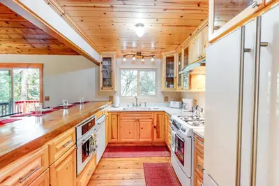 a kitchen with wooden cabinets and white appliances at Sky High Cabin in Crestline
