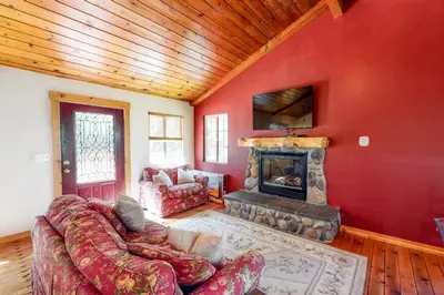 a living room with a couch and a fireplace at Sky High Cabin in Crestline