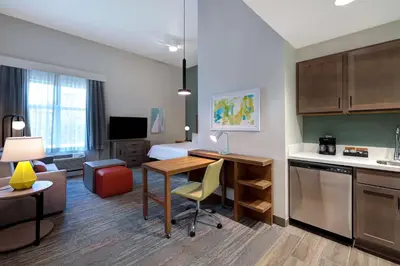 a room with a desk and a kitchen with a bed at Homewood Suites By Hilton Santa Clarita/Valencia, Ca in Santa Clarita