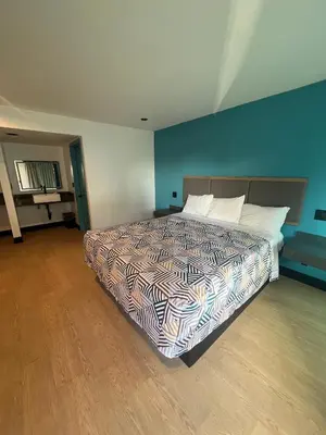 a bedroom with a bed and a blue wall at Arlo Motel near LAX, SoFi Stadium in Inglewood