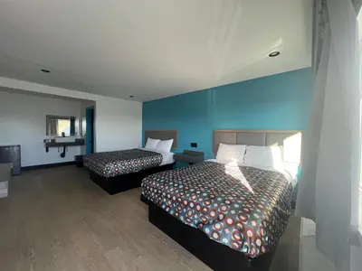 a bedroom with two beds and a blue wall at Arlo Motel near LAX, SoFi Stadium in Inglewood