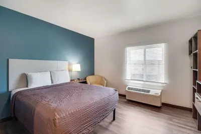 a bedroom with a large bed and a window at WoodSpring Suites Bakersfield Airport in Bakersfield