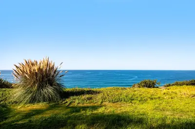 a field of grass with the ocean in the background at 50 PCT OFF! Malibu Ocean Escape, Pool, Walk to Beach in Malibu