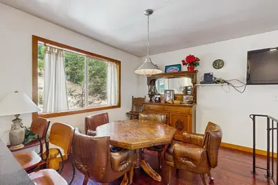 a dining room with a wooden table and chairs at Babbling Brook in Lake Arrowhead