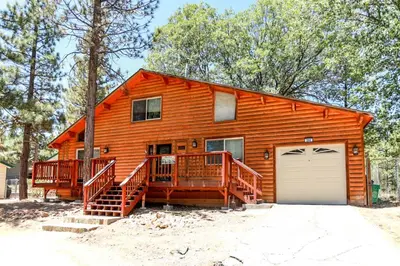 a large wooden house with a garage at Mountain Adventure - 1931 by Big Bear Vacations in Big Bear Lake