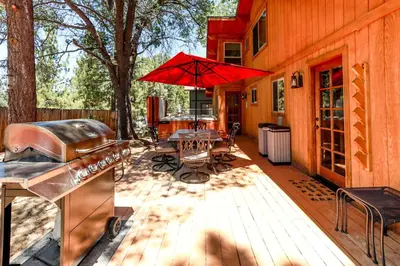 a patio with a grill and a table with an umbrella at Mountain Adventure - 1931 by Big Bear Vacations in Big Bear Lake