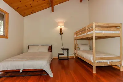 a bedroom with two bunk beds and a lamp at Shasta Mountain Cabin - 1916 by Big Bear Vacations in Big Bear City