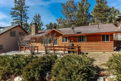 a log home with a fence in front of it at Shasta Mountain Cabin - 1916 by Big Bear Vacations in Big Bear City