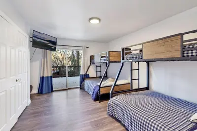 a bedroom with two bunk beds and a tv at Splash Mountain - 1904 by Big Bear Vacations in Big Bear Lake