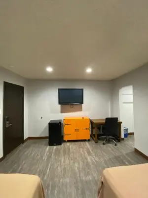 a room with a desk and a tv on a wall at Sandman Motel in Los Angeles