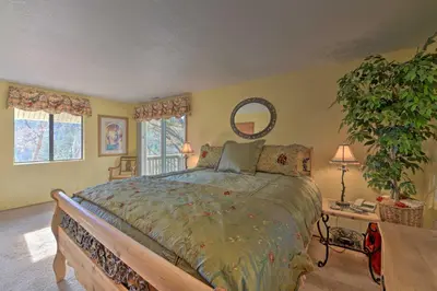 a bedroom with a large bed and a plant at Mountainside Cabin with Deck - 16 Miles to Skiing! in Lake Arrowhead