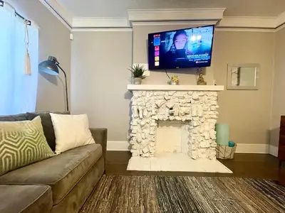 a living room with a stone fireplace with a flat screen tv at Private 1BR Apt LA Home Sweet Home in KTown\u5bb6 in Los Angeles