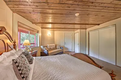 a bedroom with a bed and a couch and a chair at Lake Arrowhead Cabin with Deck and Stunning Mtn Views! in San Bernardino