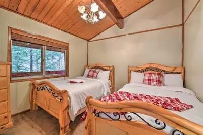 a bedroom with two beds and a window at Lake Arrowhead Cabin with Deck and Stunning Mtn Views! in San Bernardino
