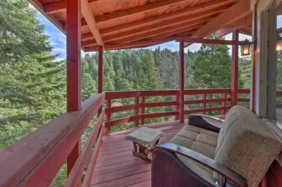 a porch of a cabin with a couch on it at Lake Arrowhead Cabin with Deck and Stunning Mtn Views! in San Bernardino