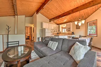 a living room with a couch and a table at Lake Arrowhead Cabin with Deck and Stunning Mtn Views! in San Bernardino