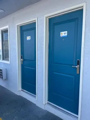 two blue doors on the side of a building at La Palma Motel, South Gate - Los Angeles area in South Gate