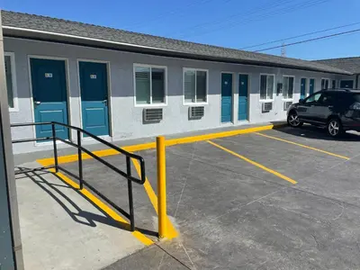 a car parked in a parking lot in front of a building at La Palma Motel, South Gate - Los Angeles area in South Gate