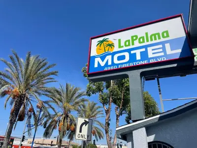 a sign for a motel with palm trees in the background at La Palma Motel, South Gate - Los Angeles area in South Gate