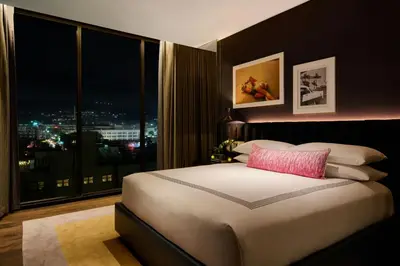 a bedroom with a large white bed with a window at The Hollywood Grande, Autograph Collection in Los Angeles