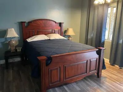 a large wooden bed in a bedroom with two lamps at LA Adventurer Hotel in Inglewood