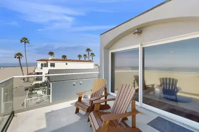 two chairs on a balcony with a view of the beach at Savor the View in Oxnard