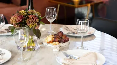 a table with wine glasses and a plate of food at Art Deco by AvantStay in Los Angeles