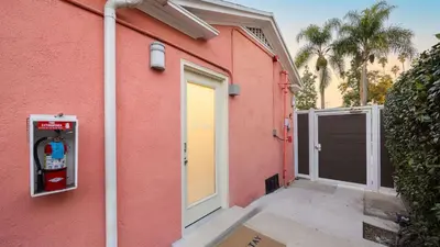 a pink building with a door and a garage at Art Deco by AvantStay in Los Angeles