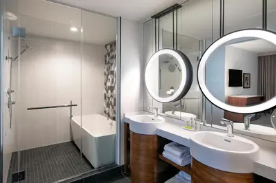 a bathroom with two sinks and a mirror at Le Meridien Pasadena Arcadia in Arcadia
