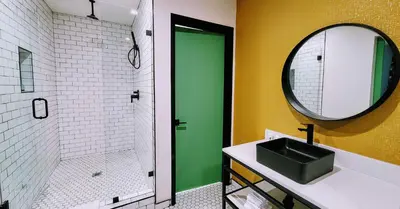 a bathroom with a sink and a shower with a mirror at The Bell Vista in Burbank