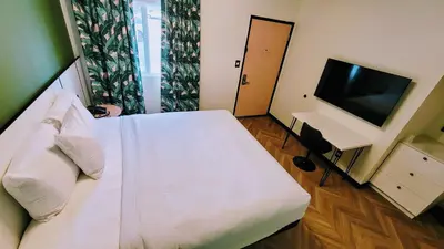 a bedroom with a white bed and a flat screen tv at The Bell Vista in Burbank