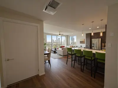 an open kitchen and living room with green bar stools at Modern Luxury Apartments in the Heart of Los Angeles in Los Angeles