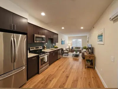 a kitchen with wooden floors and stainless steel appliances at Modern Luxury Apartments in the Heart of Los Angeles in Los Angeles