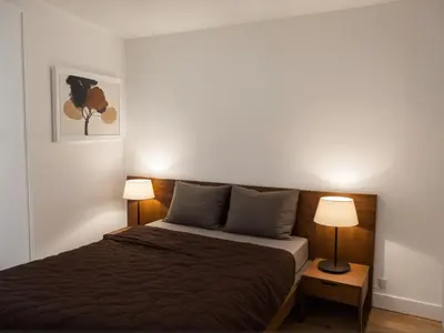 a bedroom with a bed and two lamps on tables at Modern Luxury Apartments in the Heart of Los Angeles in Los Angeles