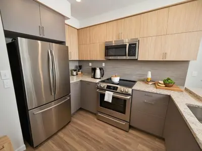 a kitchen with stainless steel appliances and wooden cabinets at Modern Luxury Apartments in the Heart of Los Angeles in Los Angeles