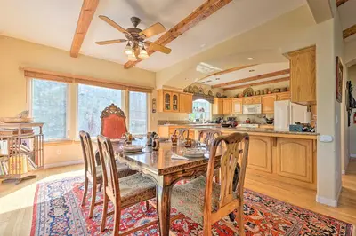 a kitchen with a table with chairs and a ceiling fan at Wraparound Deck Woodland Cabin in Lake Arrowhead in Lake Arrowhead