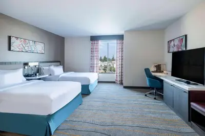 a hotel room with two beds and a flat screen tv at Hilton Garden Inn Chino Hills Pomona CA in Pomona