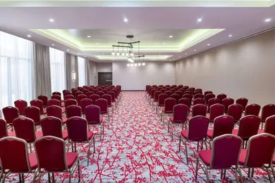 a conference room with red chairs and a screen at Hilton Garden Inn Chino Hills Pomona CA in Pomona