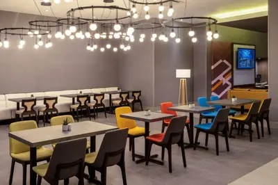 a dining room with tables and chairs and lights at Hilton Garden Inn Chino Hills Pomona CA in Pomona