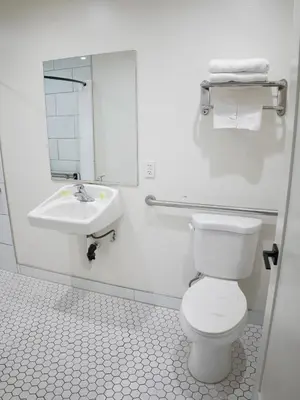 a white bathroom with a toilet and a sink at SOFI MOTEL in Los Angeles