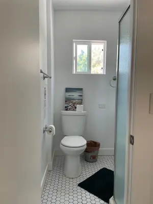 a bathroom with a white toilet and a window at The California - Hollywood in Los Angeles