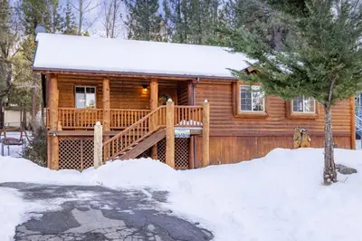 a log cabin with a deck in the snow at Little Cubs Cabin #1986 by Big Bear Vacations in Big Bear Lake