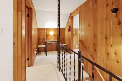 a hallway with wood paneled walls and a staircase at Conklin Paradise #1993 by Big Bear Vacations in Big Bear Lake