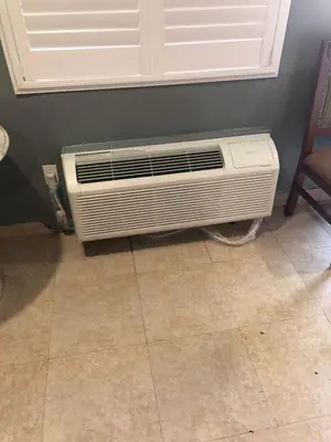 a air conditioner sitting on a floor in a room at The Fly Inn Motel in Lynwood