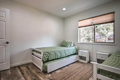 a bedroom with two beds and a window at Pine Mountain Club Villa with Sauna, Deck and Views! in Pine Mountain Club