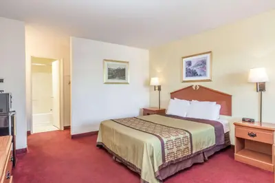 a hotel room with a bed and a television at Super 8 by Wyndham Bakersfield/Central in Bakersfield